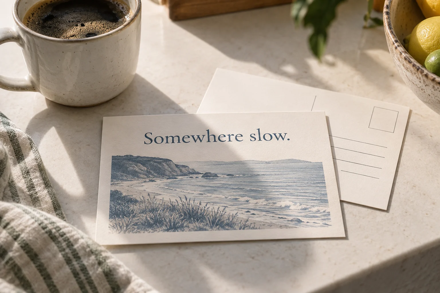 A coastal postcard on a kitchen counter beside a morning coffee